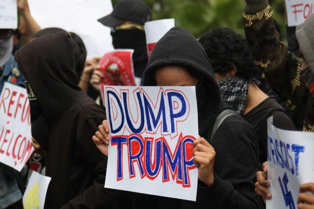 POSTER. Salah satu pengunjuk rasa membawa poster yang bertuliskan "Dump Trump" ketika menggelar aksi unjuk rasa di depan gedung Kedutaan Amerika Serikat pada Sabtu, 4 Februari. Foto oleh Diego Batara/Rappler 