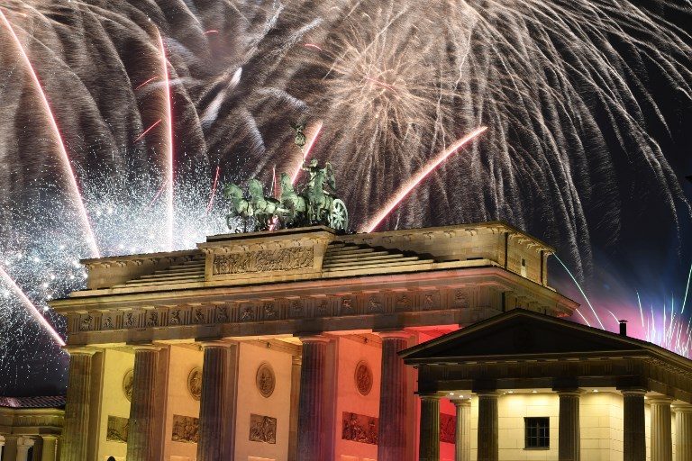 GERMANY. Fireworks explode behind the quadriga of Berlin's landmark the Brandenburg Gate to usher in the New Year. Photo by Monika Skolimowska / DPA / AFP 