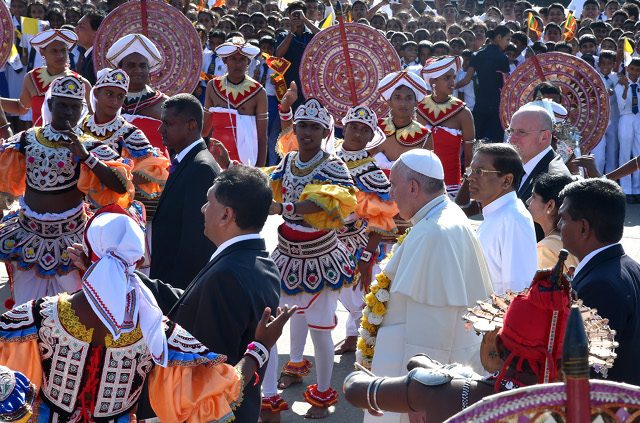 COLORFUL WELCOME. Pope Francis and Sri Lankan President Maithripala Sirisena pass through dancers in Colombo airport, Sri Lanka, January 13, 2015. Photo by Ettore Ferrari/EPA 