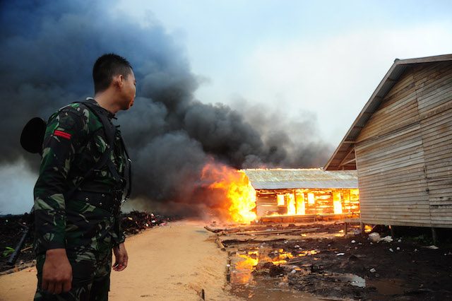 PERSECUTION. A military soldier watches ex-Gafatar settlements being burned down in West Kalimantan. ANTARA / Jessica Helena Wuysang 