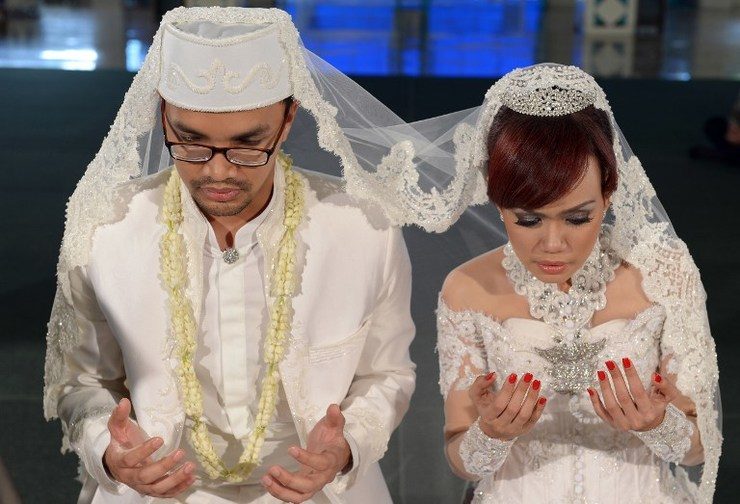 MARRIAGE ISSUES. A couple prays during their Muslim wedding ceremony at a mosque in Jakarta on December 12, 2012. File photo by AFP