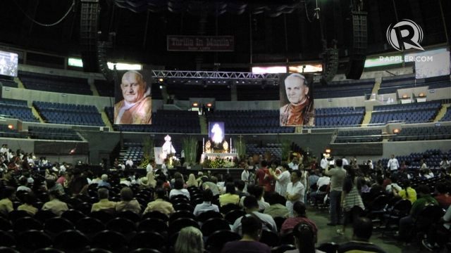 TWIN POPES. Filipinos watch a live stream of the twin canonization of Popes John XXIII and John Paul II at the Araneta Center
