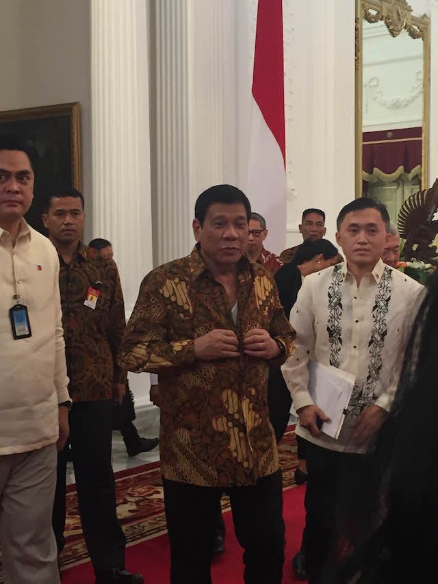 STILL BUTTONING. President Duterte was so excited to show media his batik that he came out while it was still being buttoned. Photo by Natashya Gutierrez/Rappler 