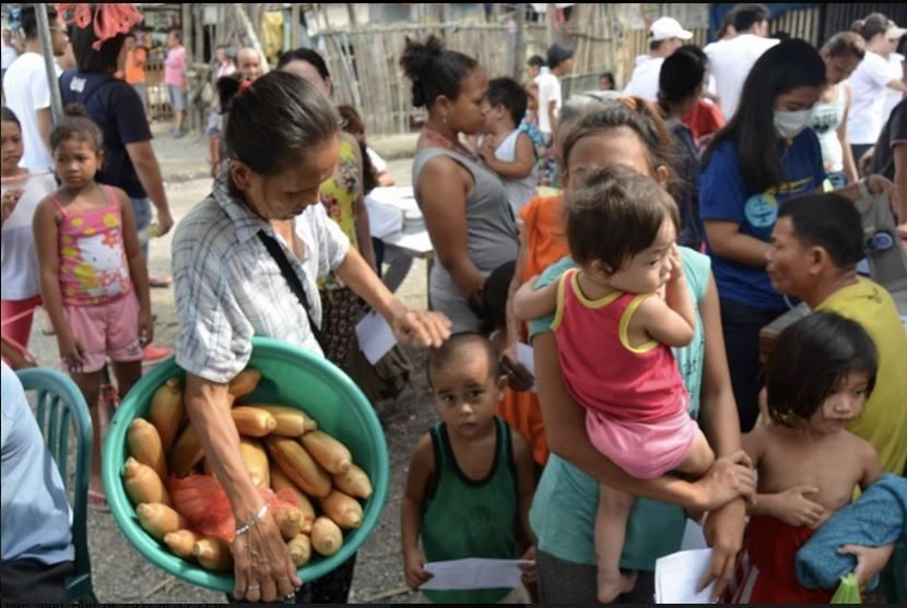 A lola paused her sale of boiled corn to bring in her three grandchildren for check up during the 2017 Medical Mission of University of Santo Tomas RCSSED. Photo Credit Aichelle Altez 