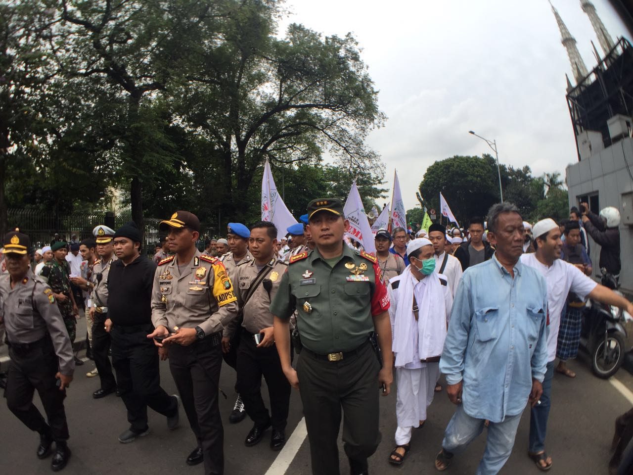 DIKAWAL. Pengunjuk rasa mendapat pengawalan dari petugas Kepolisian dan TNI. Foto oleh Zachary Lee/Rappler 