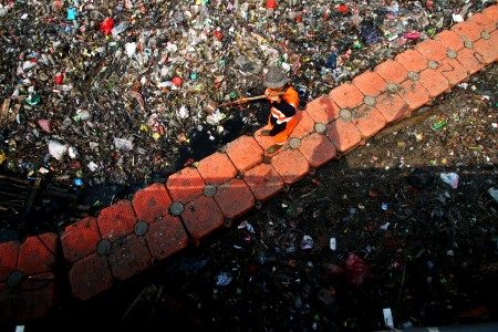 Petugas UPK Badan Air dan Kebersihan DKI Jakarta membersihkan sampah di Kali Sekretaris, Jakarta, Selasa (6/6). Foto oleh Rivan Awal Lingga/ANTARA 