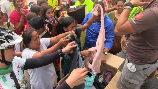 GIVING. The homeless also receive relief packs and donated clothes during FEED's event. Photo by Arlit Janry Parlero/Rappler  