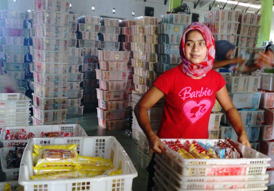 Seorang gadis Aceh mengangkat keranjang berisi roti aneka rasa di pabrik pembuatan Nusa Indah Bakery. Foto oleh Nurdin Hasan/Rappler

