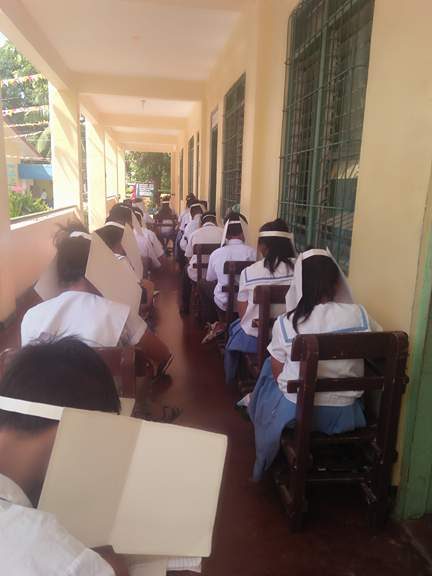 LINED. Teacher Manaug explained that since her classroom is too small for 60 students, some of the students take the exam along the hallway, still with 'anti-cheating' hats 