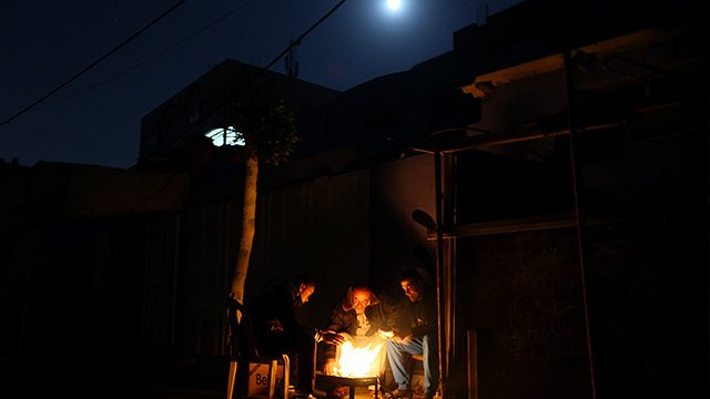 NOWHERE TO GO. Palestinian refugees sit around a fire during a power outage in Al Shateaa refugee camp next the beach in the west of Gaza City on, 27 December 2015. Mohammed Saber/EPA 