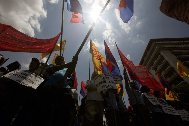 FLAGS IN THE AIR. Filipino protesters carry banners and placards during a protest march to mark Labor day in Manila, Philippines, May 1, 2014. Ritchie B. Tongo/EPA