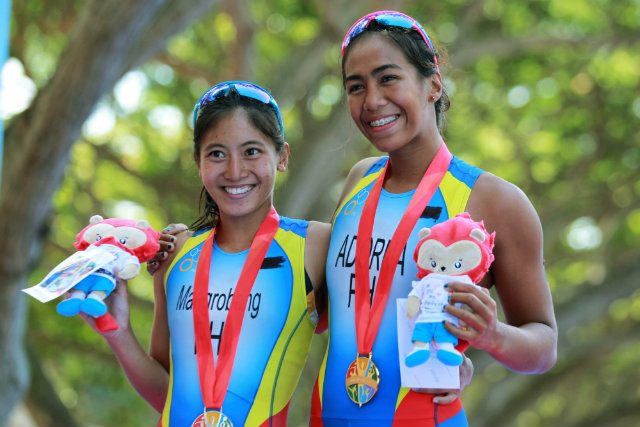 Claire Adorna (R) and Kim Mangrobang (L) show off their medals after a 1-2 finish in the SEA Games women’s triathlon event. Photo by Reuters 