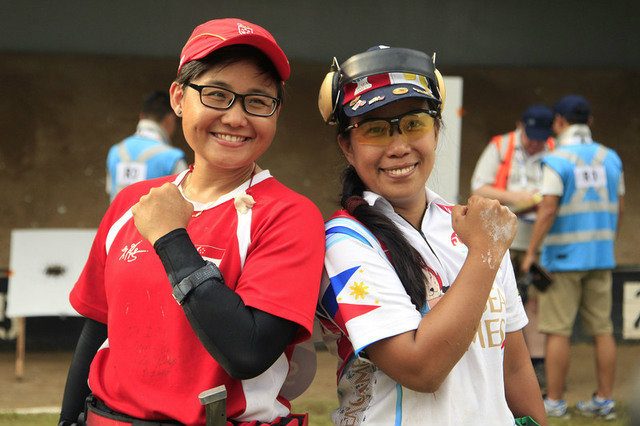 Elvie Baldivino (R) poses with Singapore's Norizan Mustafa after winning gold in the women's precision pistol event. Photo by Singapore SEA Games Organising Committee/Action Images via Reuters  