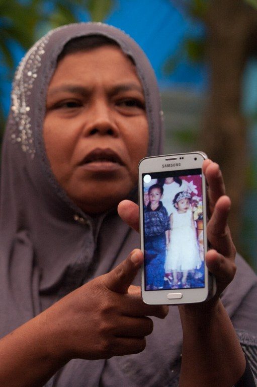 LOST CHILDREN. Jamaliah displays a picture of Raudatul and Arif taken before the 2004 tsunami. Photo by Chaideer Mahyuddin/AFP 