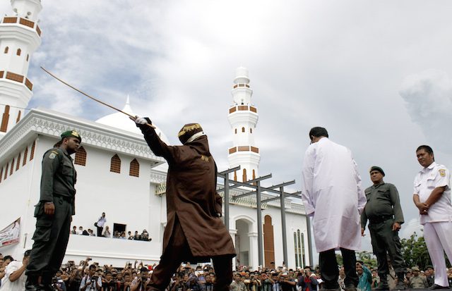 Seorang warga Aceh menerima hukuman cambuk. Pelaku dihukum menurut hukum syariat Islam, bagi mereka yang berjudi, mabuk, atau pelaku LGBT. Foto oleh EPA  