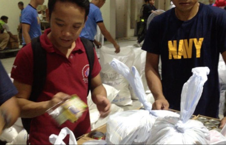 SACRIFICE. Robert Pelayo helps pack relief goods for communities affected by the typhoon