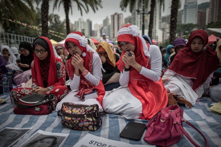 MOURNING. Indonesian migrant workers pray during a vigil for two Indonesian murder victims in Hong Kong on November 9, 2014. Photo by Philippe Lopez/AFP
