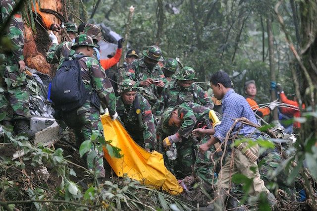 Tentara dan sukarelawan mengevakuasi tubuh korban kecelakaan pesawat Casa C-212 di Gunung Salak, pada 28 Juni 2008. Foto oleh Adek Berry/AFP 