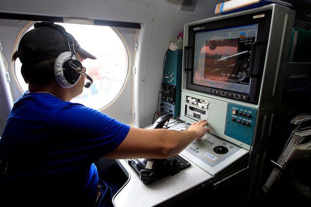 A Russian search and rescue team member shows their searching monitor inside their amphibian aircraft BE 200 CS as they show their aircraft during their search and rescue operation for crashed AirAsia plane at Iskandar Military Airport in Pangkalan Bun, Central Kalimantan, Indonesia, on January 7, 2015. Photo by Bagus Indahono/EPA 