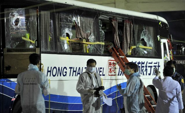 CRIME. Members of a Hong Kong police forensic team examine the tourist bus used in the hostage-taking incident on August 23, 2010 by an ex-policeman. File photo by Noel Celis/AFP