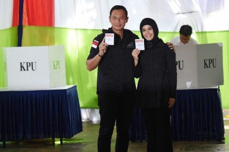 Calon Gubernur DKI Jakarta Agus Harimurti Yudhoyono (kiri) bersama istri, Annisa Pohan (kanan) menunjukkan surat suara saat melakukan pencoblosan Pilkada DKI Jakarta di TPS 6, Rawa Barat, Jakarta, Rabu (15/2). Foto oleh Akbar Nugroho Gumay/ANTARA 