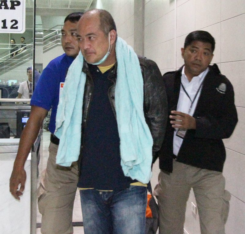  CAUGHT. Former Coron mayor Mario Reyes is escorted by police upon arrival at NAIA shortly past 3 am Friday, September 25. Photo by Jedwin Llobrera