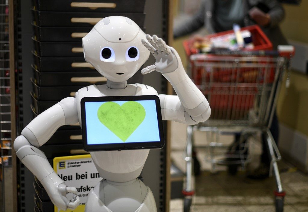 Humanoid robot "Prepper" stands on April 2, 2020 at the cash desk of a supermarket of the Edeka retail chain in Lindlar, western Germany, to explain protective measures and to promote solidarity with each other, amid the novel coronavirus pandemic. Photo by
Ina Fassbender/AFP 