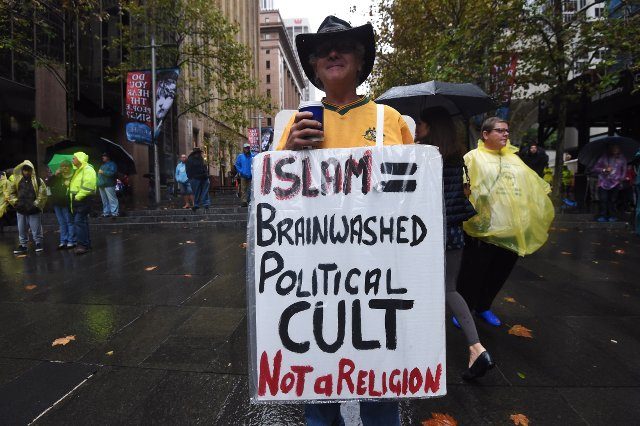 Seorang warga Australia dalam demonstrasi ‘Reclaim Australia’ membawa spanduk anti-Muslim di Sydney, pada 4 April 2015. Foto oleh EPA