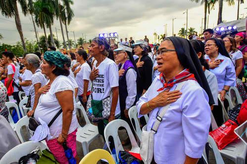 FAITH AND PATRIOTISM. Nuns and ordinary citizens sing the Philippine National Anthem. Photo by Maria Tan/Rappler  