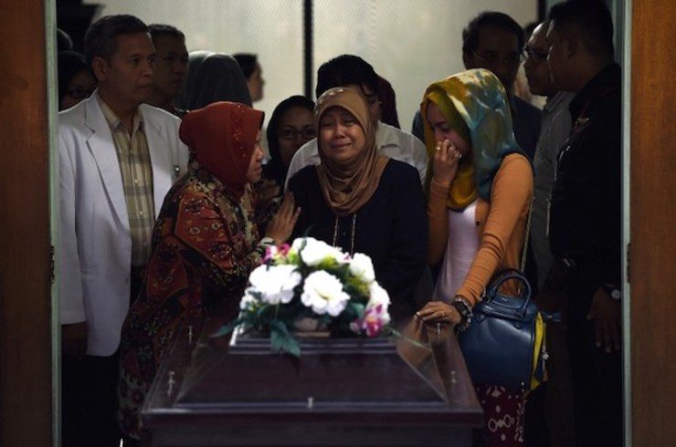 First AirAsia funeral as bad weather hampers search