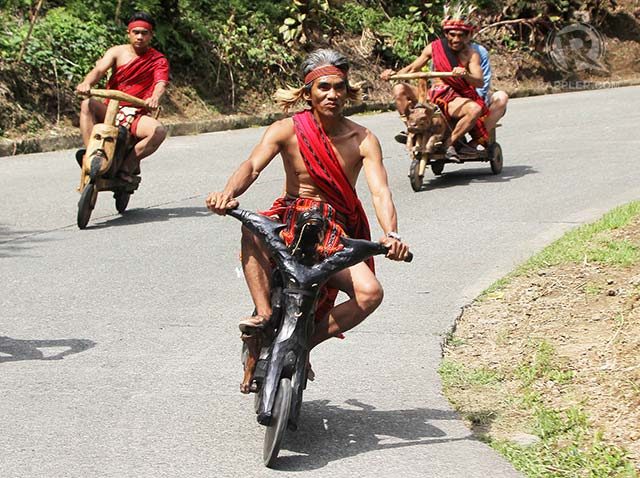 RACE. Tribesmen race with their wooden scooters during the festival.