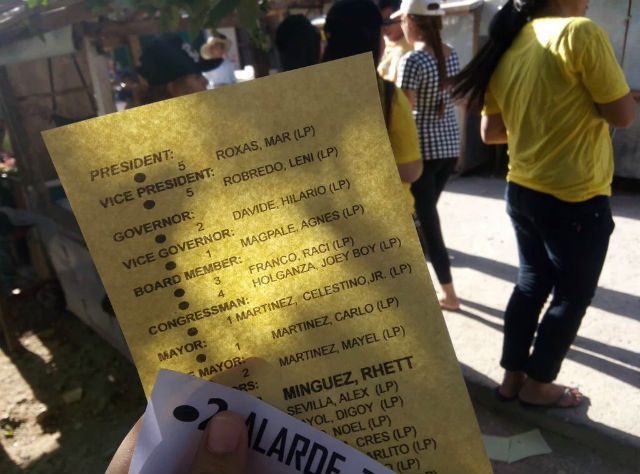KODIGO. These papers were allegedly handed outside a precinct in northern Cebu by campaigners in yellow t-shirts. Photo by Richale Cabauatan  