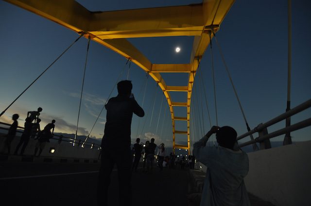 Warga menyaksikan fase puncak Gerhana Matahari Total (GMT) yang dilihat dari PALU. Jembatan Teluk Palu, Sulawesi Tengah, Rabu (9/3). Fenomena alam yang hanya terjadi selama 350 tahun sekali itu dimanfaatkan warga dengan menyaksikan secara langsung pada lokasi terbuka. Foto oleh Mohamad Hamzah/Antara 