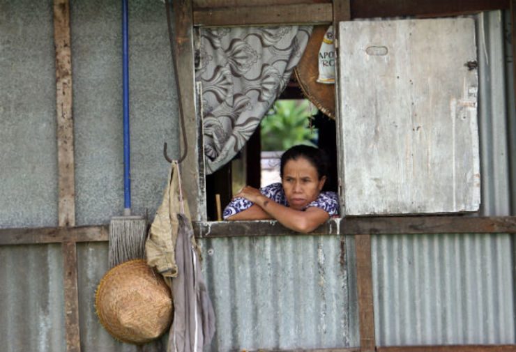 HOW MANY ARE POOR? A woman looks out of her window at a slum area in Jakarta. File photo by EPA
