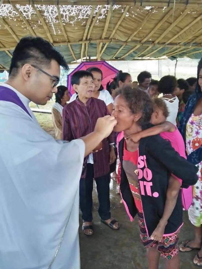 SPIRITUAL GIFT. An Aeta mother receives holy communion during a mass which is part of an outreach activity organized by seminarians in Ilagan City, Isabela. Photo courtesy of Jeff Limon  
