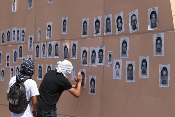 Two students hang photographs of the 43 missing youth, in Guerrero state, Mexico, 07 October 2014. José Luis de la Cruz/EPA
