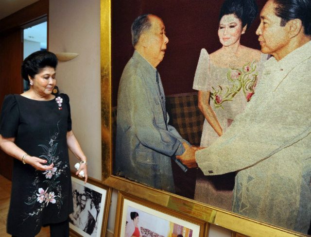 MARCOS AND MAO. This photo taken on August 31, 2009, shows former Philippine first lady Imelda Marcos (left) walking past a giant portrait of her late husband, former president Ferdinand Marcos (right), shaking hands with Chinese leader Mao Zedong (center). File photo by Ted Aljibe/AFP 