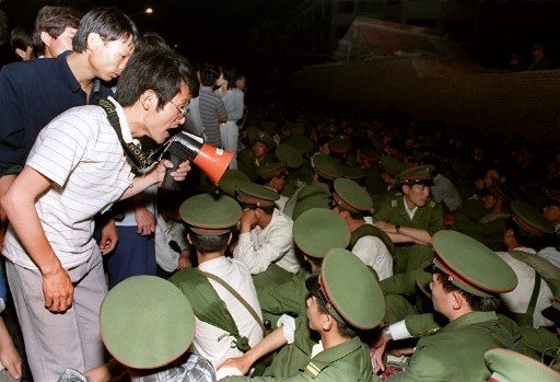 STUDENT'S VOICES. Using a loudspeaker, a student asks soldiers to go back home as crowds flooded into the central Beijing on June 3, 1989. On the night of June 3 and 4, 1989, Tiananmen Square sheltered the last pro-democracy supporters. Photo byÂ Catherine Henriette/AFP 