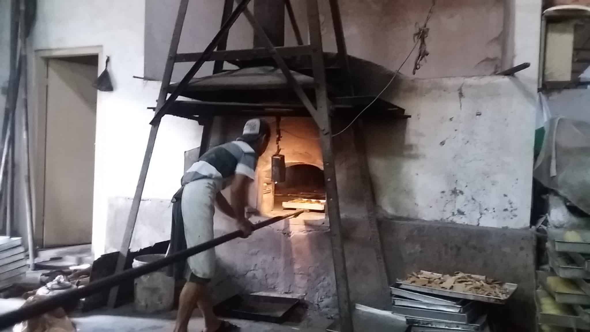 Seorang pekerja mengambil roti yang telah masak usai dipanggang di oven kuno berusia ratusan tahun. Foto oleh Irma Muflikah/Rappler 