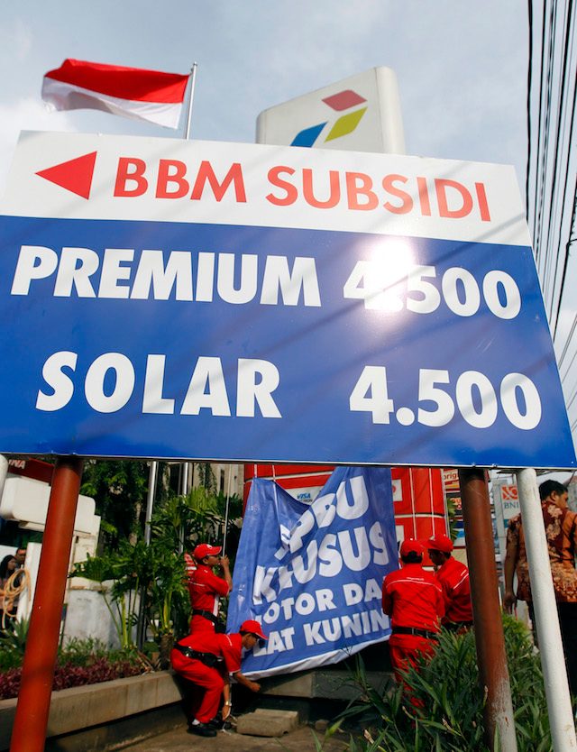 Petugas sedang memasang banner di sebuah stasiun pengisian bahan bakar di Jakarta, 26 April 2013. PT Pertamina pada saat itu mematok harga Premium bersubsidi dengan oktan 88 dari Rp 4,500 per liter dan Solar Rp 4.500 per liter. Foto oleh Bagus Indahono/EPA  