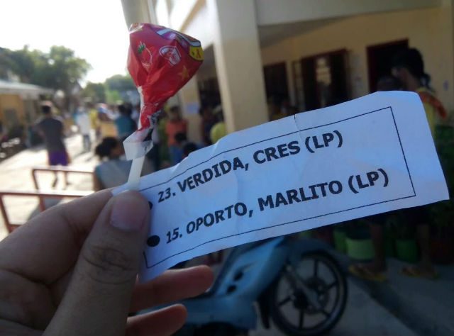 CANDIES. Local candidates allegedly gave out candies with names of candidates outside of a precinct in northern Cebu  