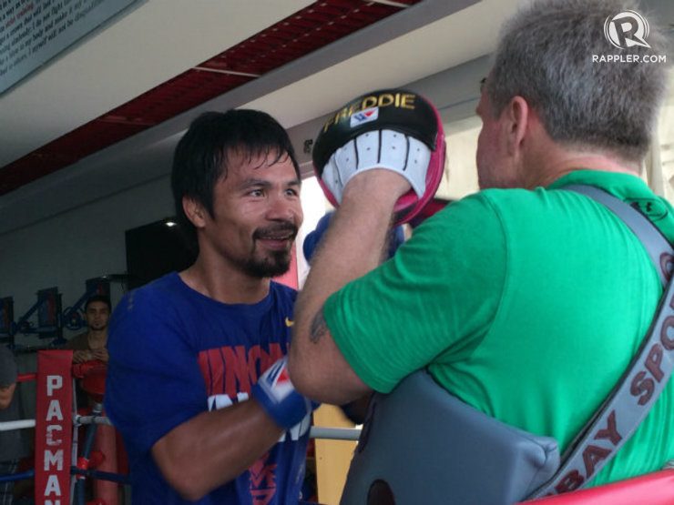 Manny Pacquiao offers a smile as he works away on the punch mitts. Photo by Ryan Songalia/Rappler