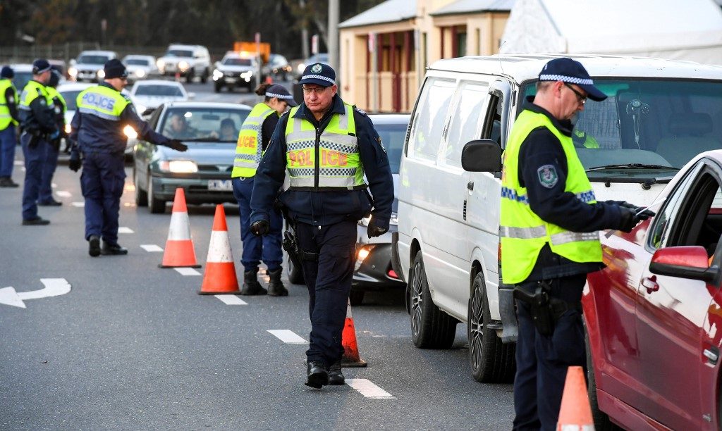 LOCKDOWN. Police in the southern New South Wales (NSW) border city of Albury check cars crossing the state border from Victoria on July 8, 2020 after authorities closed the border due to an outbreak of COVID-19 coronavirus in Victoria. Photo William West/AFP  