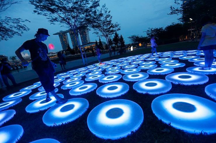Acrobat Thomas Hauffen from Norway twirls a LED poi as he walks over light art installation titled 'The Pool' by Jen Lewin Studio of USA during the i Light Marina Bay 2014 festival in Singapore, 19 March 2014. How Hwee Young/EPA