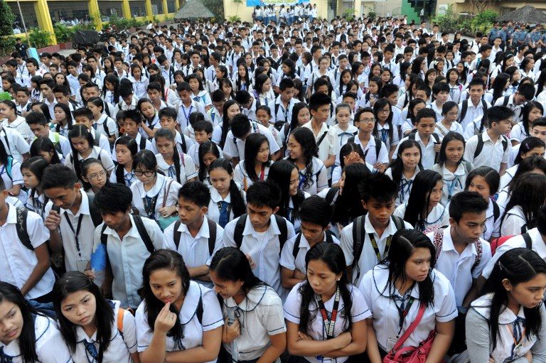 CLASSES. Students attend a flag raising ceremony before singing the national anthem at a government school in Manila. Photo by Jay Directo/AFP 