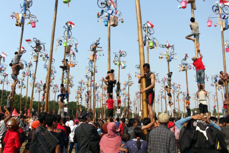 CLIMBING CONTEST. Indonesians participate in a competition to reach prizes on top of the logs during a palm tree climbing race held to mark the 69th anniversary of Indonesia's independence day in Jakarta. Photo by EPA/Adi Weda