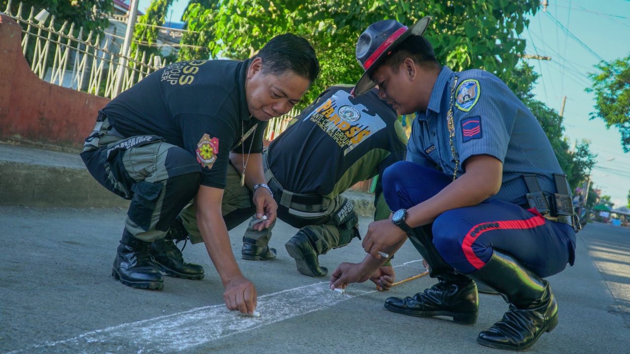 CHALK-DRAWN. The Cagayan Philippine National Police - Highway Patrol Group draws pedestrian lanes using chalk in front of Tuguegarao East Central School. Photo by Vee Salazar/Rappler 