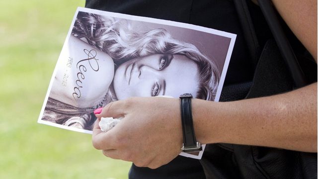 A mourner holds a photo of slain model Reeva Steenkamp during her funeral in February 2013. AFP file