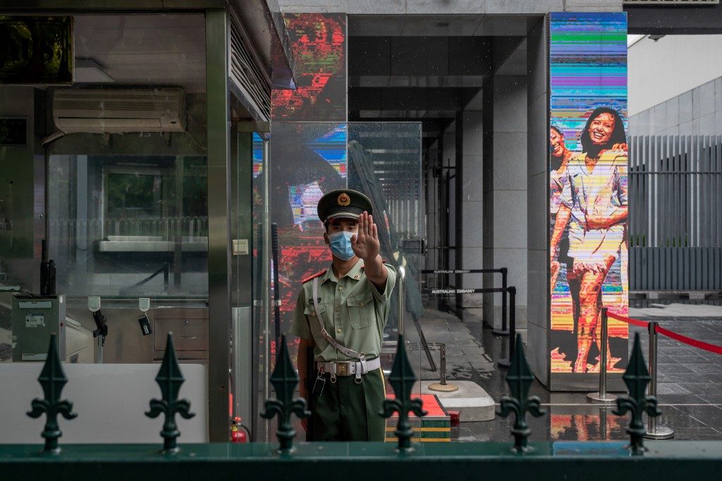 HALT. A Chinese paramilitary police officer gestures while standing at the entrance gate of the Australian embassy in Beijing on July 9, 2020. Photo by Nicolas Asfouri/AFP  