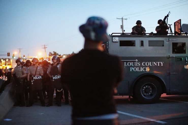 SECURITY FORCE. Police stand watch as demonstrators protest the shooting death of teenager Michael Brown on August 13, 2014 in Ferguson, Missouri. Scott Olson/Getty Images/AFP